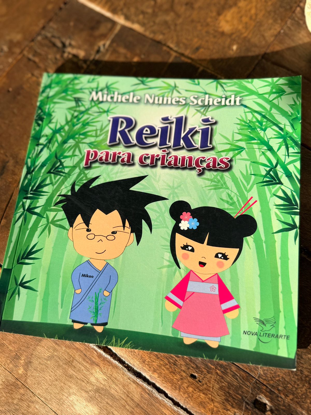Exemplar do livro Reiki para Crianças sobre mesa de madeira