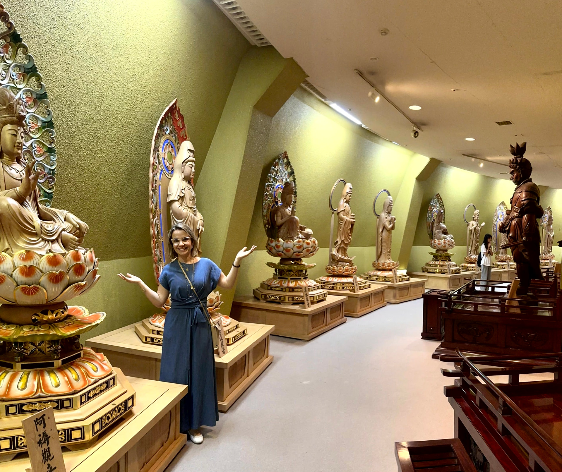 Michele na galeria interna do Sendai Daikannon, entre as esculturas das manifestações de Kuan Yin